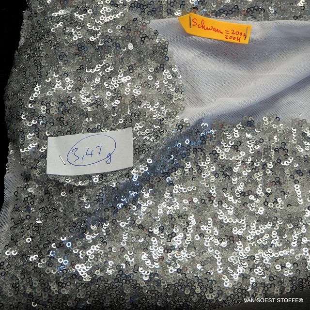 Glänzende mini Silber Pailletten auf weißen Stretch Tüll