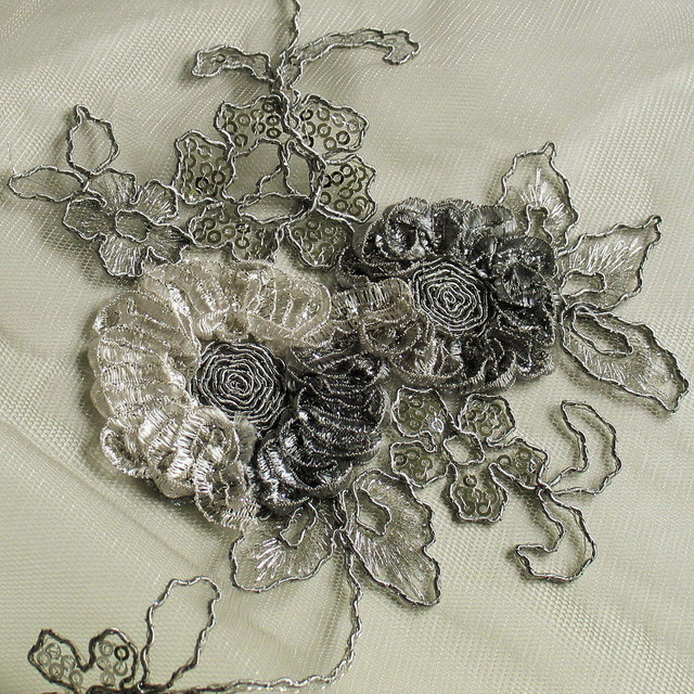 Silver coloured flower lace on grey coloured mesh